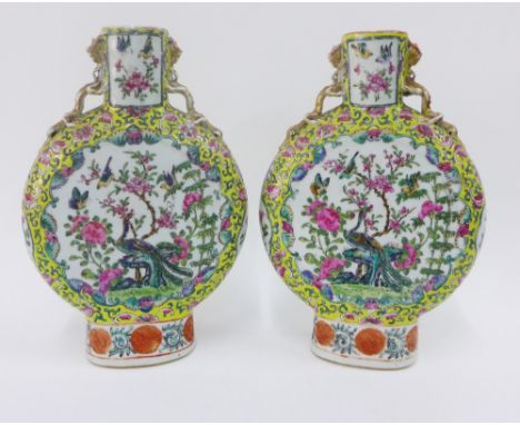 A pair of Chinese moon flask vases, painted with peacocks, flowers and foliage to a famille jaune ground, with mythical beast