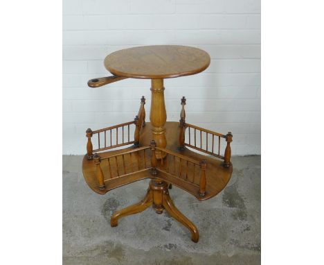 Revolving reading table, circular top with candle holder, over a cruciform and balustrade shelf on splayed legs, 64 x 77cm 