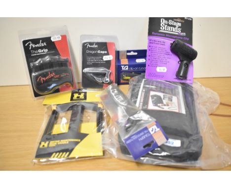 A bundle of accessories including guitar maintenance kit, Fender capo and grip aid, hercules cradle, tuner etc