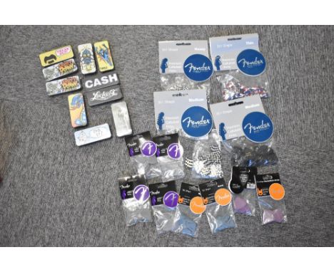 A large selection of guitar picks including Fender and Dunlop illustrated pick tins