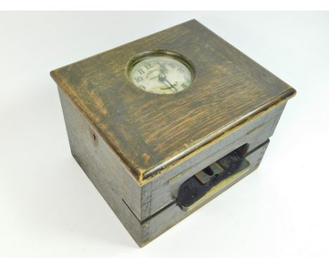 CLOCKING-IN RECORDER. A Gledhill Brook oak table top, clocking-in recorder. 30x25x21cm.  All clocks in this auction are previ