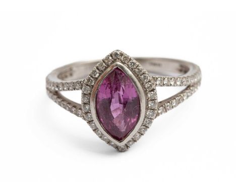 A platinum pink sapphire and diamond dress ring, set with a marquise mixed cut pink sapphire, within a border of round brilli
