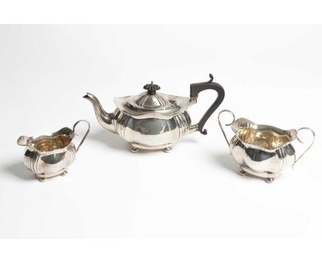 A bachelor's three-piece silver tea set, Birmingham 1915, of lobed oval shape with wavy rims, on compressed bun feet, the tea
