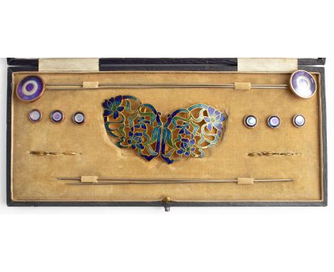 An Art Nouveau enamel buckle and hat pin cased set, the butterfly shaped gilt metal and enamelled buckle with sinuous flowers