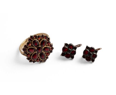 A yellow metal and garnet flowerhead cluster ring, ring size R, unmarked assessed as a minimum of 9ct gold, gross weight appr