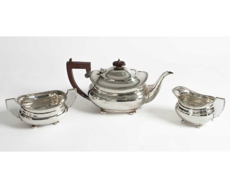 A silver three piece tea set, Adie Brothers, Birmingham 1934, the teapot with wooden handle, 1097g