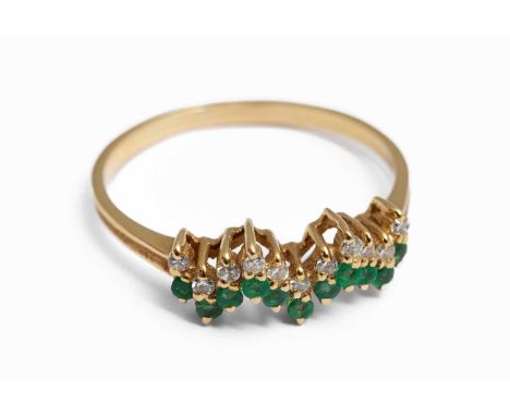 A yellow metal emerald and diamond ring, set with three round cut emeralds and eight small round cut diamonds, ring size S½, 