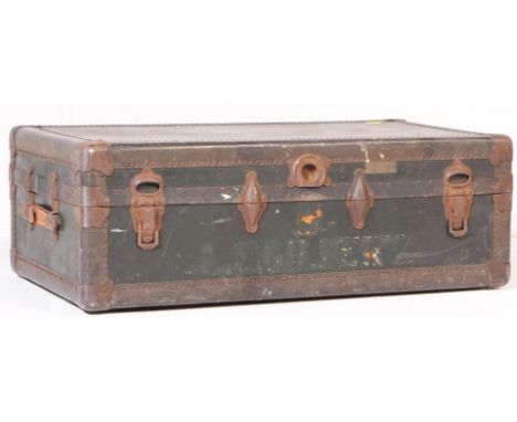 A vintage 20th century railway travel trunk suitcase. Of rectangular form with brass bound and stud work. Twin leather carry 