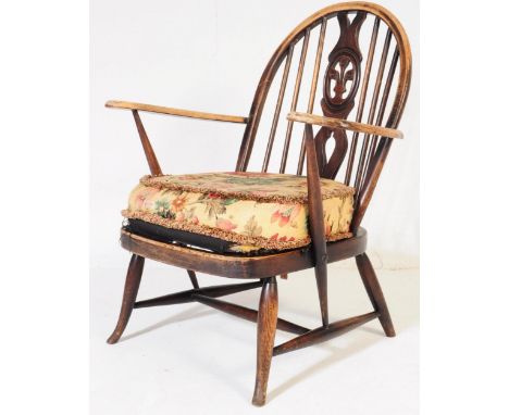 A retro vintage mid 20th century Ercol beech and elm low armchair. With&nbsp;fleur de lys stick back rest, shaped arm rests w