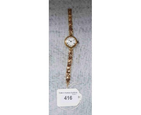 A YELLOW GOLD WRISTWATCH with white enamel dial and mounted on a 15ct yellow gold sprung gatelink bracelet