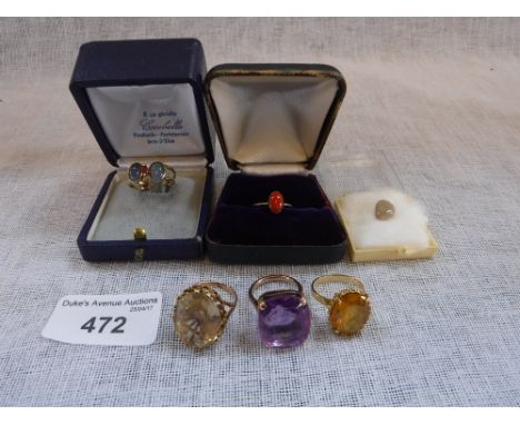 A CORAL AND GOLD SOLITAIRE RING, an amethyst cocktail ring and three other rings with a loose opal