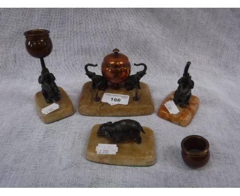A DESK SET comprising an inkwell with elephant mounts and similar candlesticks and paperweight