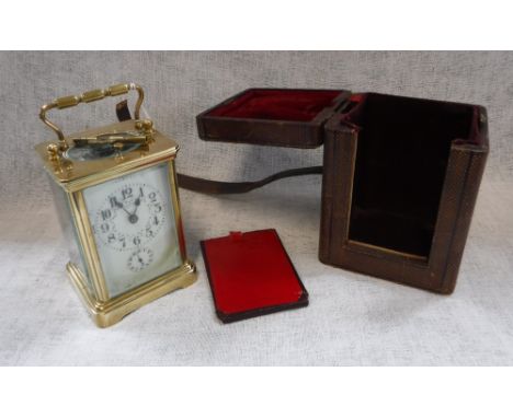 A BRASS-CASED CARRIAGE CLOCK with decorated dial in leather carrying case