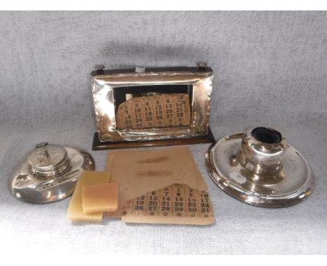 A SILVER CAPSTAN'S TYPE INKWELL with presentation engraving to 'J Ashton-Radcliffe' another similar and a silver framed calen