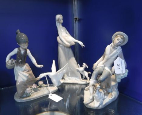 A LLADRO FIGURE of a young man and dog and two similar ornaments