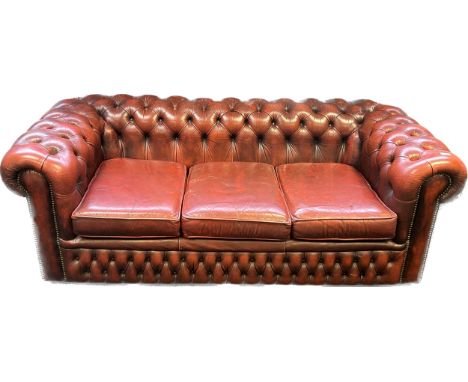 Chesterfield settee, covered in a red leather button upholstery 