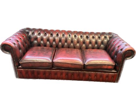 Chesterfield settee, covered in a red leather button upholstery 