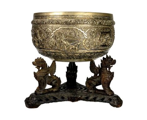 A large Indian silver bowl, circa 1900.  Repousse decorated with figures and animals in landscapes and buildings, on a carved