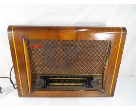 A vintage Pye radio marked Cambridge England in wood veneered case and attached electric cable, two front switches for tuning