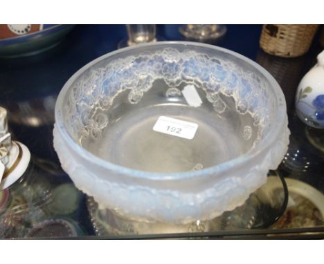 R LALIQUE; A CIRCULAR OPALESCENT GLASS BOWL decorated with flowers in relief, 16 cm dia.