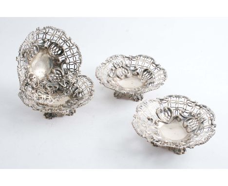 A SET OF FOUR LATE VICTORIAN BONBON DISHES with openwork, floral scroll bases & scrollwork borders, by Messrs. Hutton & Sons,