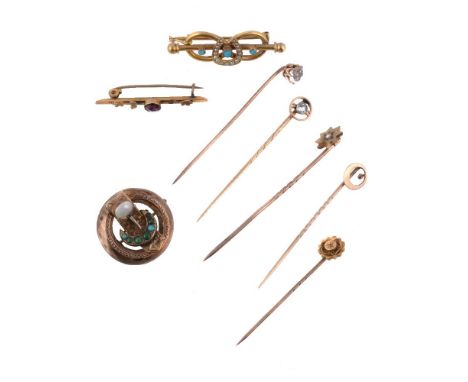 A diamond stick pin, set with an old cut diamond in a halo surround, 5.7cm long; four further stick pins; and three gem set b