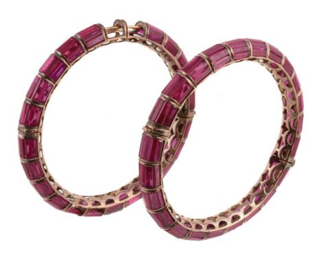 A pair of 1970s synthetic ruby bangles, the baguette cut synthetic rubies within channel settings, concealed clasps, inner di