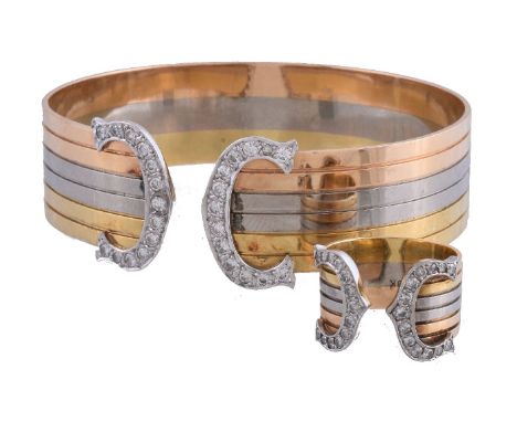 A three colour diamond bangle, the reeded bangle with diamond set C shaped terminals, approximately 0.75 carats total, stampe