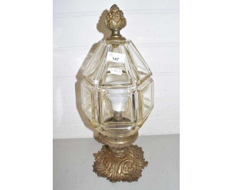 A brass ceiling light fitting with faceted clear glass shade