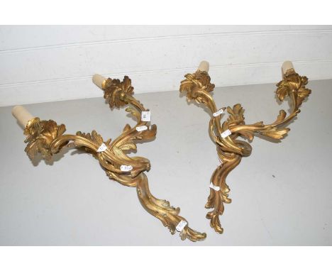 A pair of brass foliate formed twin light wall sconces