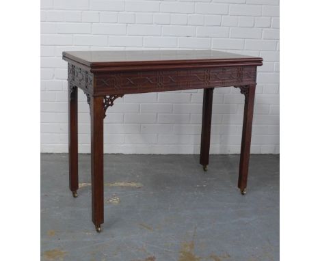 George III Chippendale style mahogany table, the fold over top with blind fret carved frieze, on square legs, terminating on 