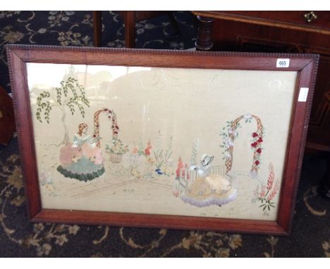 An early 20th century oak framed and glazed embroidery picture: Ladies in Crinoline dresses in garden setting.