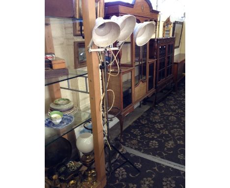 An Industrial adjustable floor standing triple lamp.