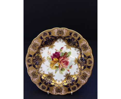 A Royal Worcester porcelain plate, decorated with Roses, painted by Frank Roberts with gilt and blue decorated border.