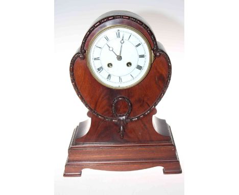 Shaped mahogany mantel clock raised on bracket feet with enamelled and Roman numeral dial, 34cm by 25cm.