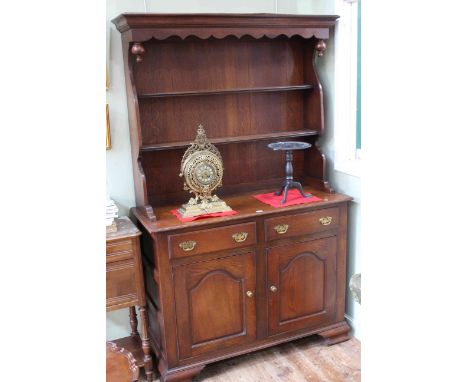Oak shelf back dresser having two drawers above two arched fielded panel doors on ogee bracket feet, 189cm by 116.5cm.
