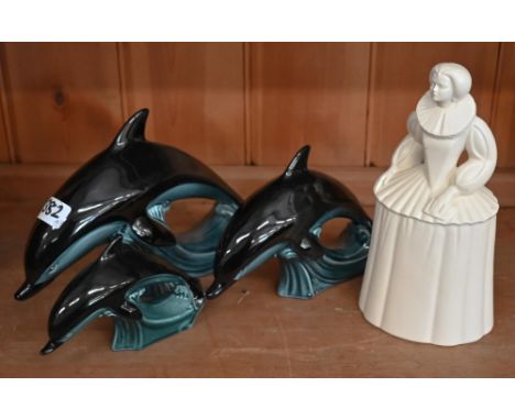A Poole pottery figure of Queen Elizabeth I, 24 cm, to/w a graduated set of three Poole dolphins (4) 