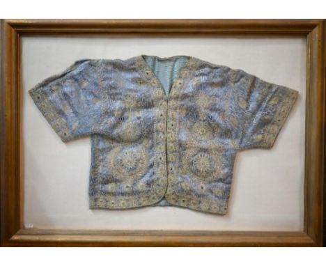 A vintage Northern Indian embroidered jacket with gold and silver thread on a blue ground, in glazed frame 