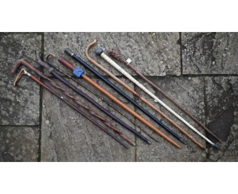 Various vintage walking sticks and canes, including shark vertebrae cane, Masonic carved wood cane, ebony and white/metal can