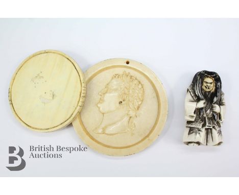 19th century ivory portrait, depicting a classical profile, approx 70mm diameter together with an ivory amulet approx 60 mm d