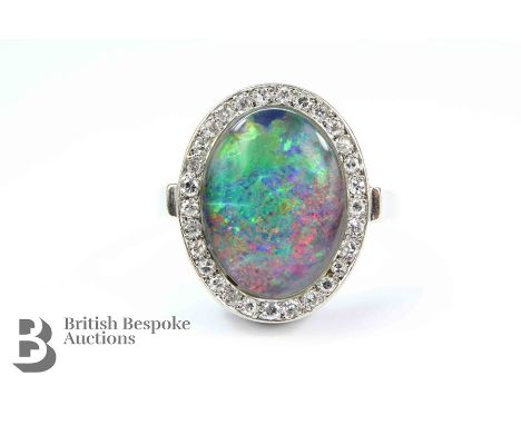 14ct White gold black opal and diamond ring, the impressive oval opal measures approx 17 x 13mm, surrounded by approx 45 pts 