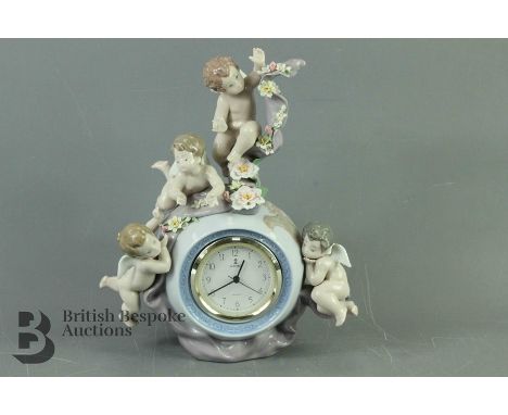 Lladro figural mantel clock, nr 5973, a circular globe surmounted by winged putti and floral garlands, approx 30 cms h, white