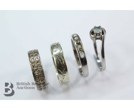 Four 9ct gold rings. This lot includes a 9ct aquamarine ring size O, white stone size O, floral engraved wedding band size M,