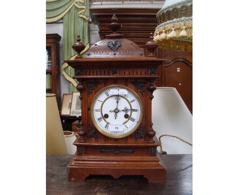A 19th century oak-cased mantel clock with enamel face and Roman numerals