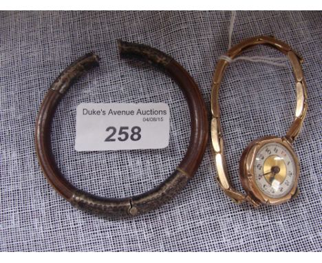 A ladies yellow metal cased wristwatch, with silvered Arabic numeral dial and an eastern bentwood and silver mounted bangle (