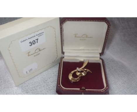 A modern 18ct yellow gold ribbon-tie brooch, with diamond-set centre, in the original fitted case for Thomas Cleaver of Rugby