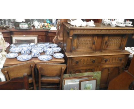 A light oak court cupboard, a draw-leaf table and four matching dining chairs