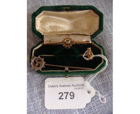 An Edwardian peridot and gold bar brooch, a silver stick-pin modelled with the Isle of Man legs and another gold coloured sti