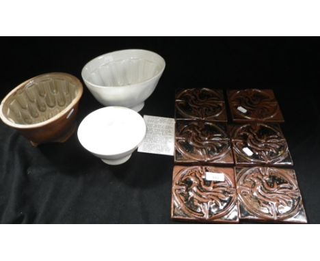 A set of six pottery tiles attributed to Michael Leach and three jelly moulds