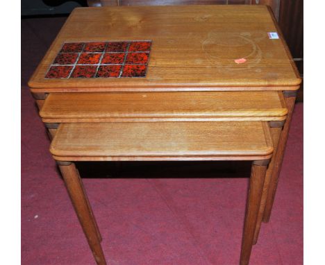 A 1970s teak and part tile inset nest of three occasional tables, on turned supports, the largest w.55.5cm